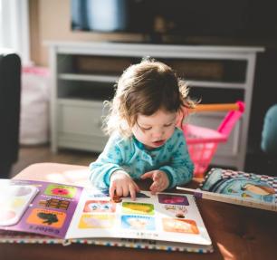 Female toddler reading a picture book