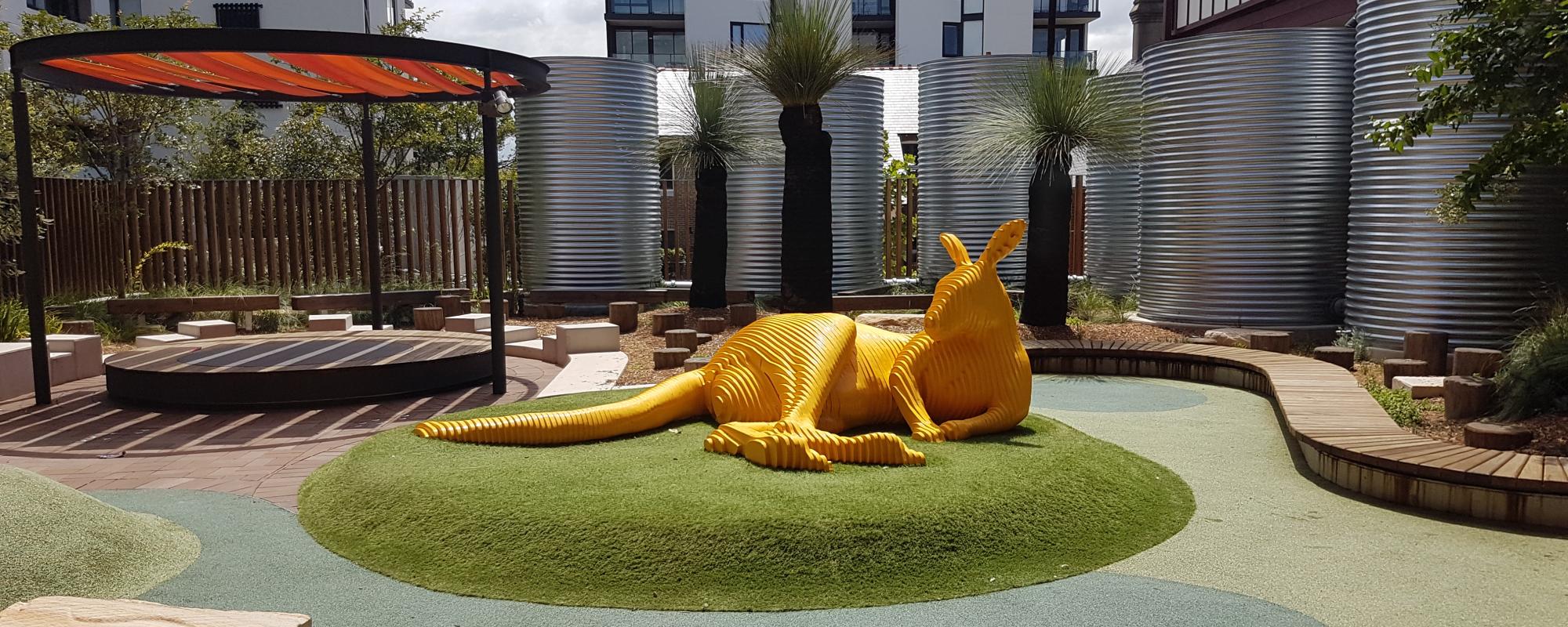 Large yellow sculpture of kangaroo outdoors