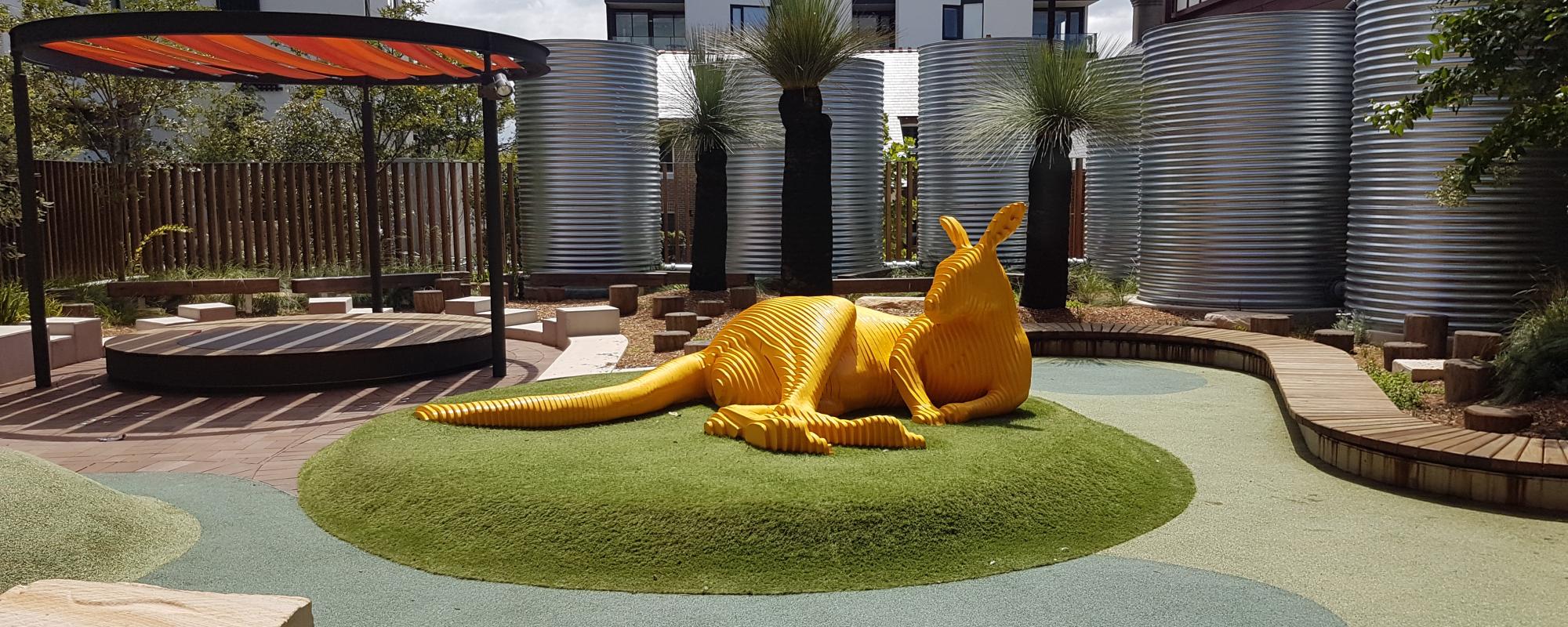 Large yellow sculpture of kangaroo outdoors