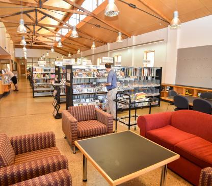 Seating, bookshelves and people inside a library
