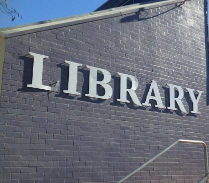 Sign on side of building that says library