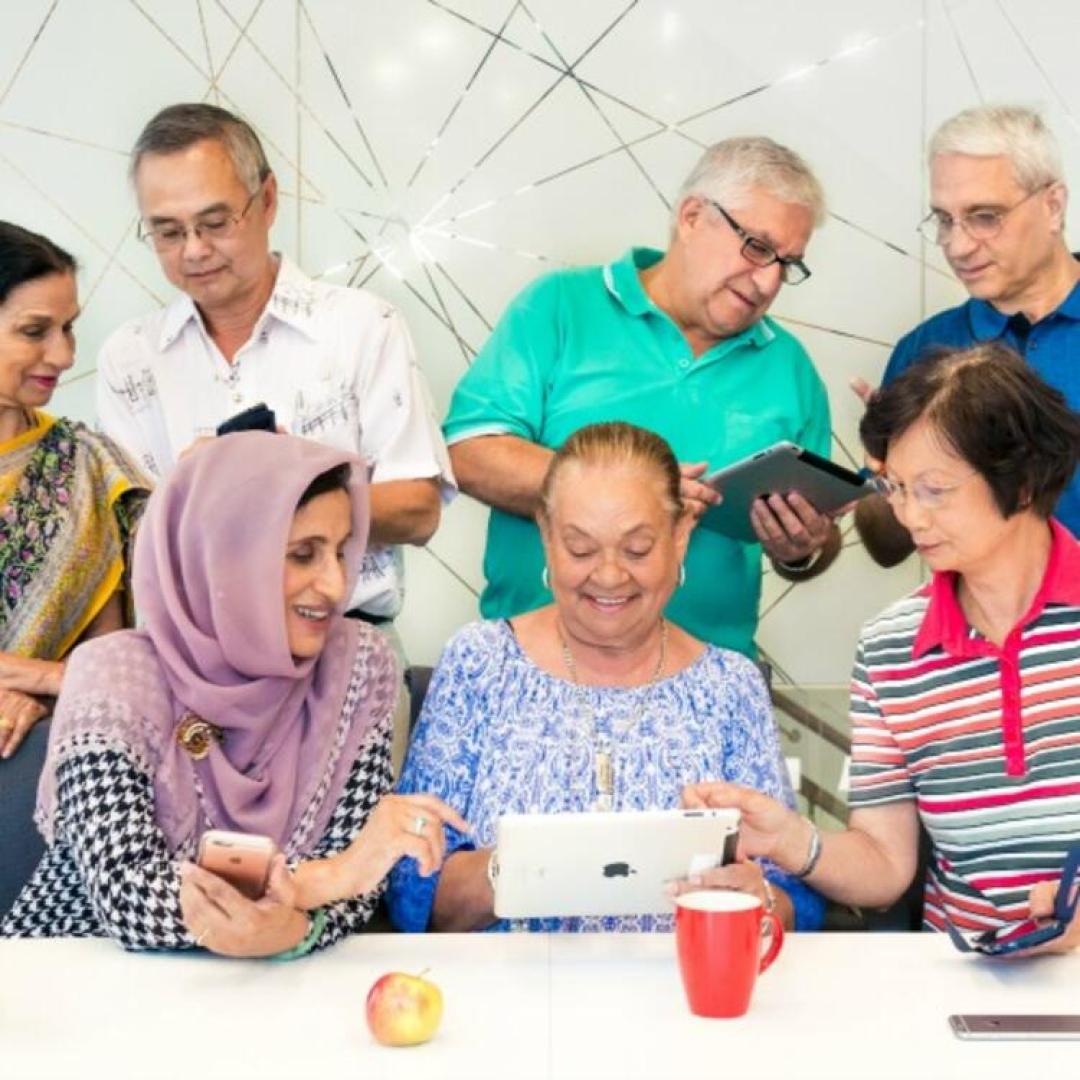 Group of older people looking at electronic devices